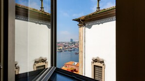 Vista desde una ventana sobre un paisaje urbano con edificios y una masa de agua.