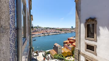 Vista de un río con edificios a la otra orilla, cielo despejado y una escalera que baja a una calle.