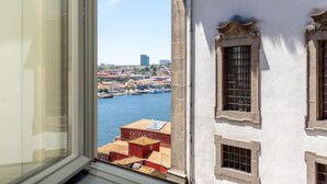 A view from a window overlooking a waterfront with buildings and a clear sky. - Feel Porto Code al Studio 1 2 (Porto)