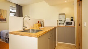 A compact kitchen with a sink, microwave, and cabinets. - Feel Porto Code al Studio 1 2 (Porto)