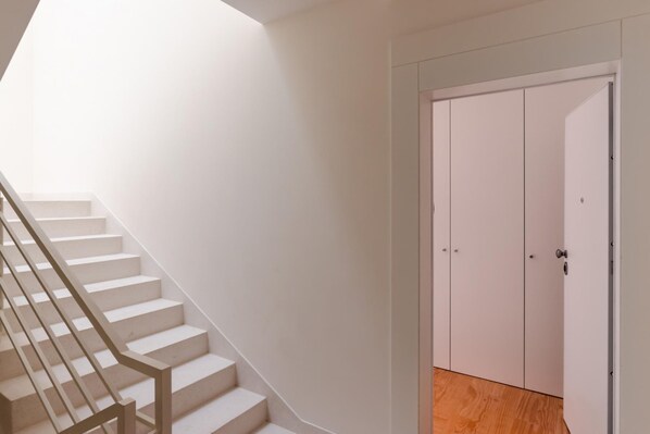 A staircase with a handrail leading to a white door with two panels. - Feel Porto Downtown Theater Studio (Porto)