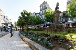 A public square with a statue, cobblestone pavement, and flower beds. - Galerias Iconic Nightlife 204 by Feel Porto (Porto)