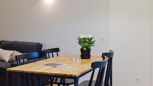 A small, modern room with a wooden dining table, black chairs, a black sofa, and a potted plant. - Galerias On Trend Nightlife 203 by Feel Porto (Porto)