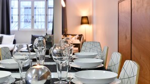 Comedor con una mesa dispuesta para cuatro, incluyendo copas de vino, platos y una vela.