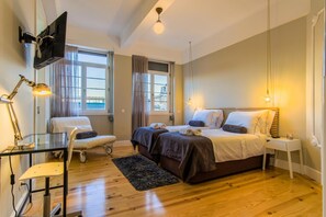 A bedroom with a bed, bedside tables, a desk with a lamp, and a TV mounted on the wall. - Feel Porto Downtown Art Tile (Porto)