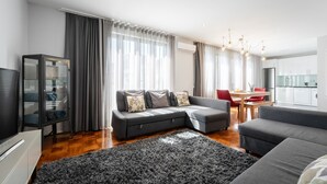 A modern living room with a grey sofa, a black shag rug, and a glass cabinet. - Feel Porto DOC Townhouse (Porto)