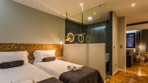 A modern hotel room with two beds, a large mirror, and a small seating area. - Feel Porto Vintage Townhouse (Porto)