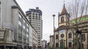 A street view with a mix of modern and historic buildings, including a church with blue and white tile work. - Feel Porto Merlot Townhouse (Porto)