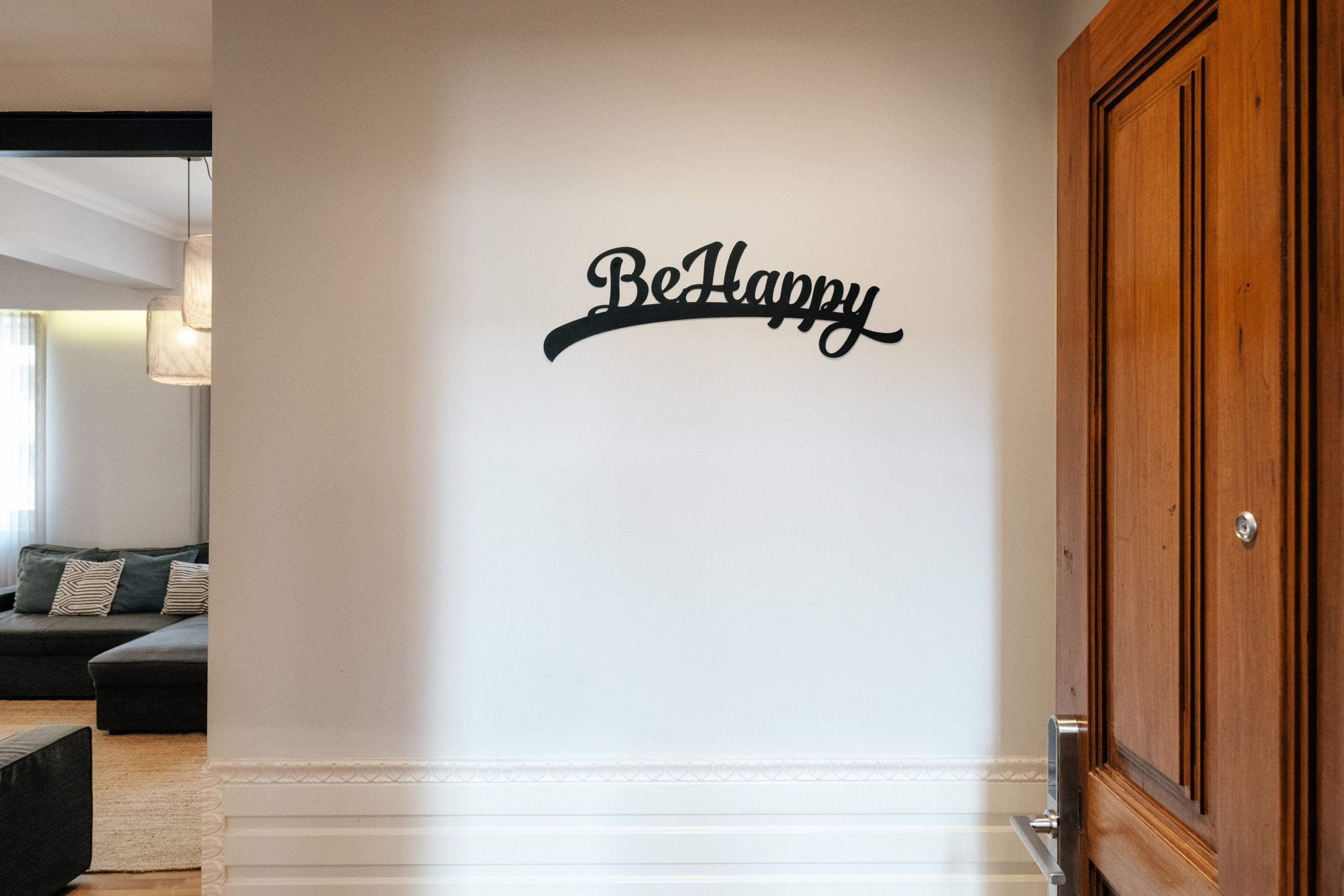 A wall with the text 'Be Happy' in a decorative font.