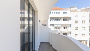 A narrow balcony with a glass door, white walls, and a view of adjacent buildings. - Feel Porto Pinot Townhouse (Porto)