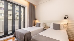 A hotel room with two beds, a large window, and a view of the outside building. - Feel Porto Pinot Townhouse (Porto)