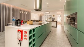 A modern kitchen with green cabinets, a white countertop, and stainless steel appliances. - Feel Porto Pinot Townhouse (Porto)