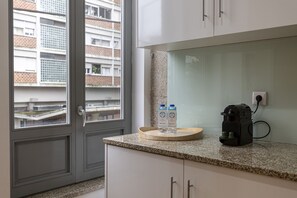 Une cuisine dotée d’un plan de travail en granit, d’une machine à café et de deux briques de lait.