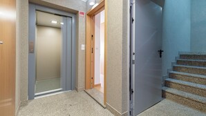 An elevator, a door, and a staircase in a building. - Feel Corporate Housing Marqu s IV (Porto)