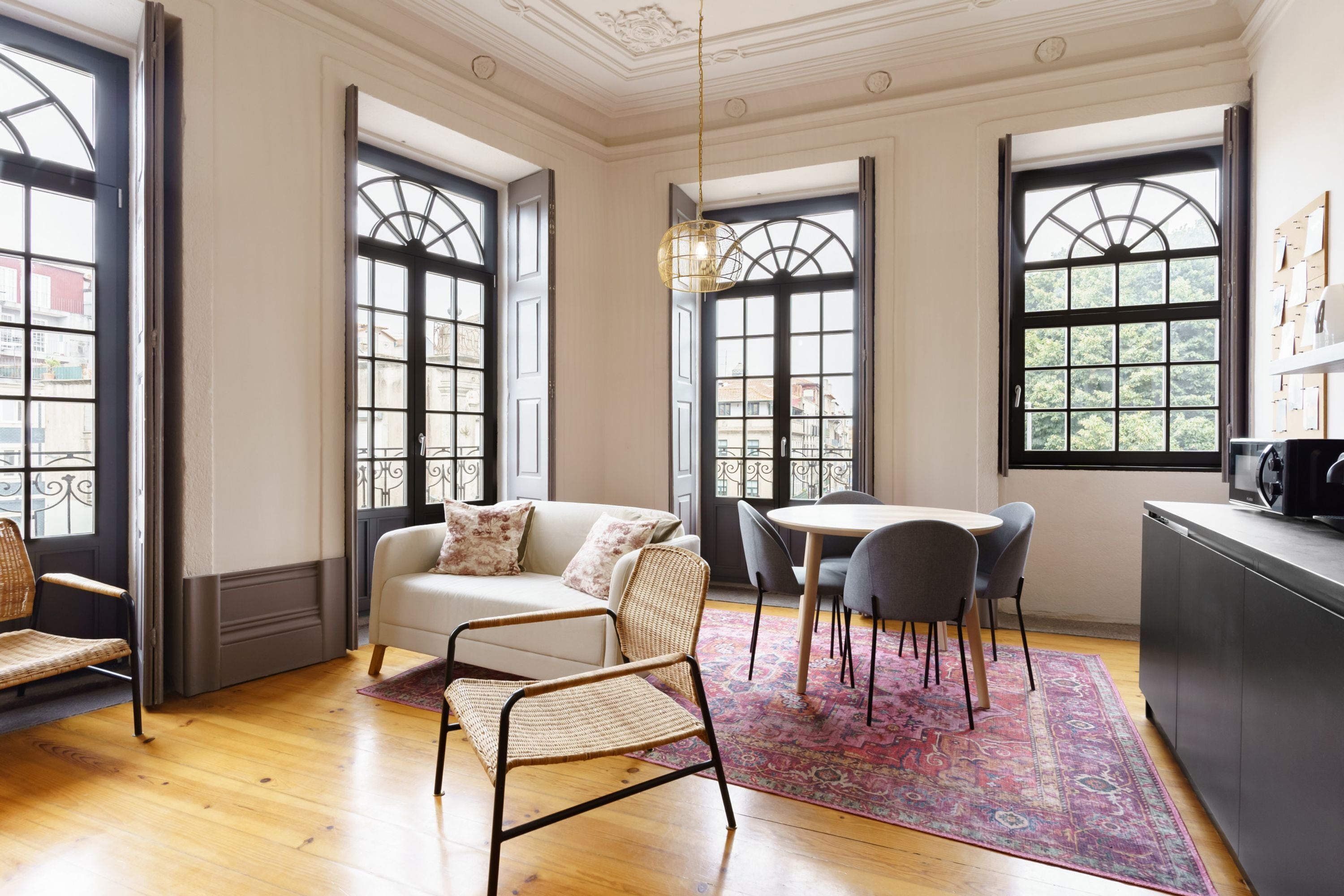 Una habitación con sofá, sillas, una mesa de comedor y una zona de cocina.
