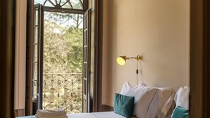 A hotel room with a bed, a window with a view of trees, and a wall-mounted lamp. - Feel Porto Antique Poveiros Flat II (Porto)