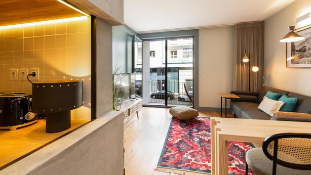 Uma sala de estar moderna com um sofá, uma mesa de centro e um espaço de jantar.
