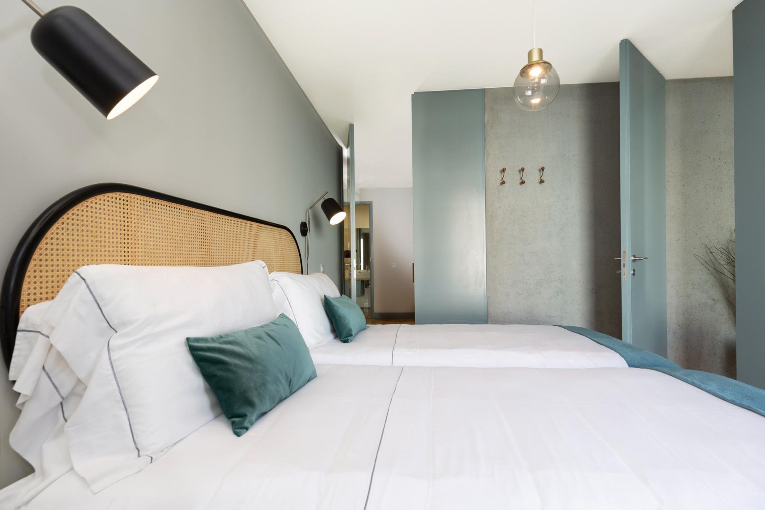 Un dormitorio moderno con una cama grande, cabecera y un armario.