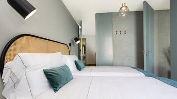 A modern bedroom with a large bed, a headboard, and a wardrobe.