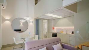 A modern living room with a sofa, a glass table, and a round mirror. - Feel Porto Matosinhos Ocean Flat V (Matosinhos)