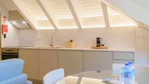 Una cocina moderna con horno empotrado, pileta y cafetera en la encimera.