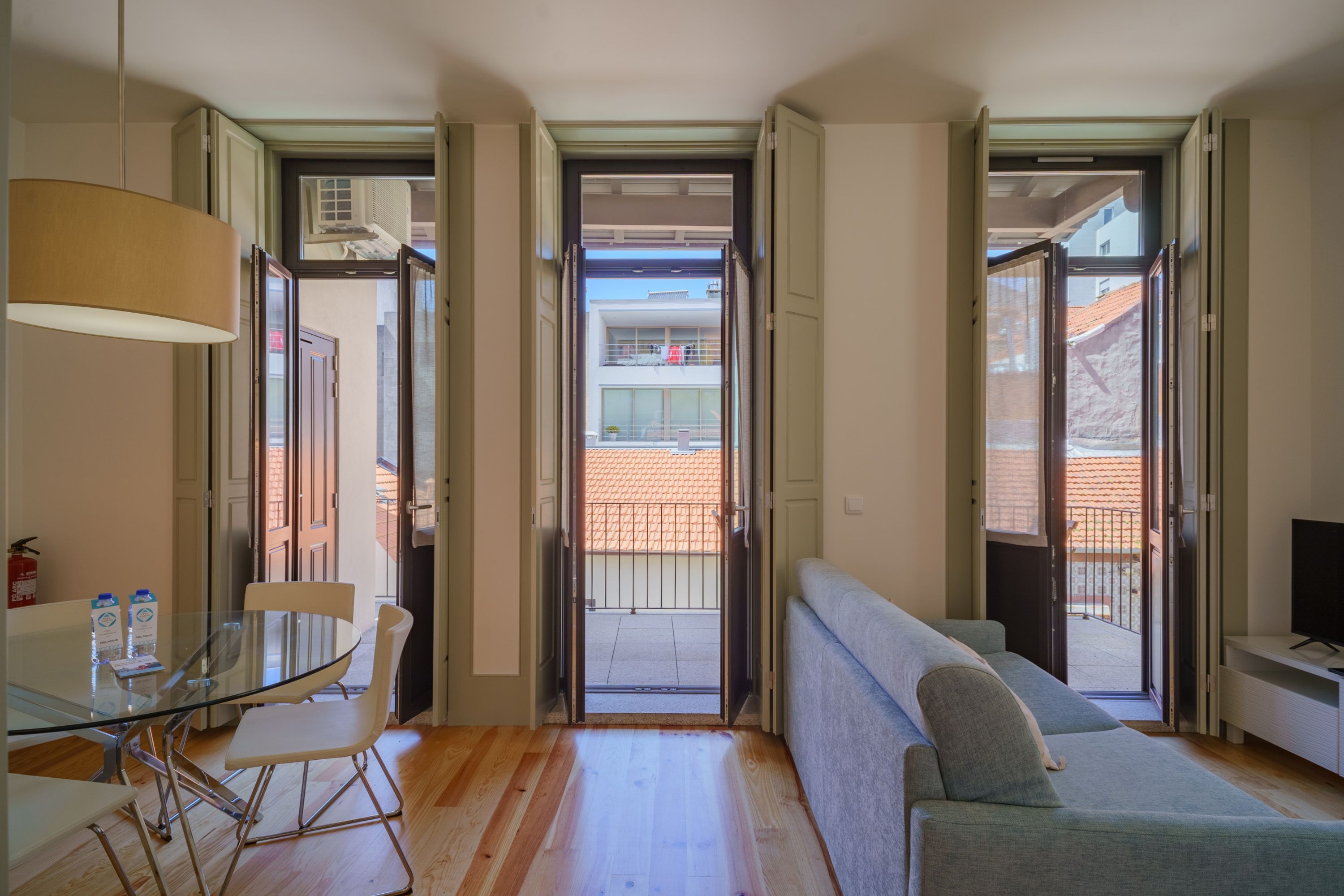 Una sala de estar moderna con una mesa de vidrio, un sofá y un televisor.