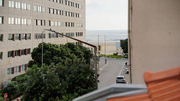 Vista de una calle que lleva a una playa, con un edificio en primer plano.