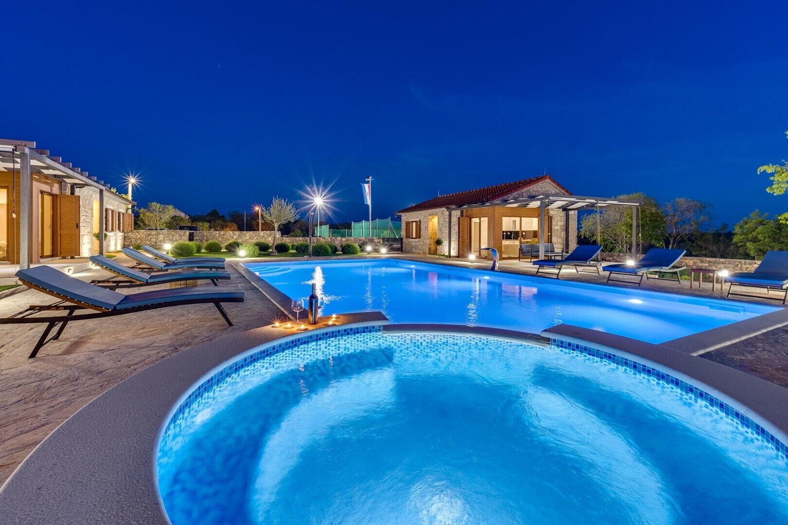 A swimming pool with lounge chairs and a building in the background.