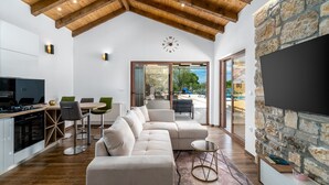 Uma cozinha moderna com forno embutido e uma área de refeições com sofá e cadeiras.