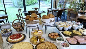 Un buffet de petit-déjeuner proposant un assortiment de viennoiseries, de fruits et de fromages.