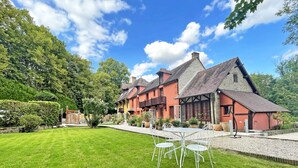 Il s’agit d’un bâtiment de style chalet traditionnel, doté d’une pelouse bien entretenue et d’un espace extérieur aménagé pour s’asseoir.