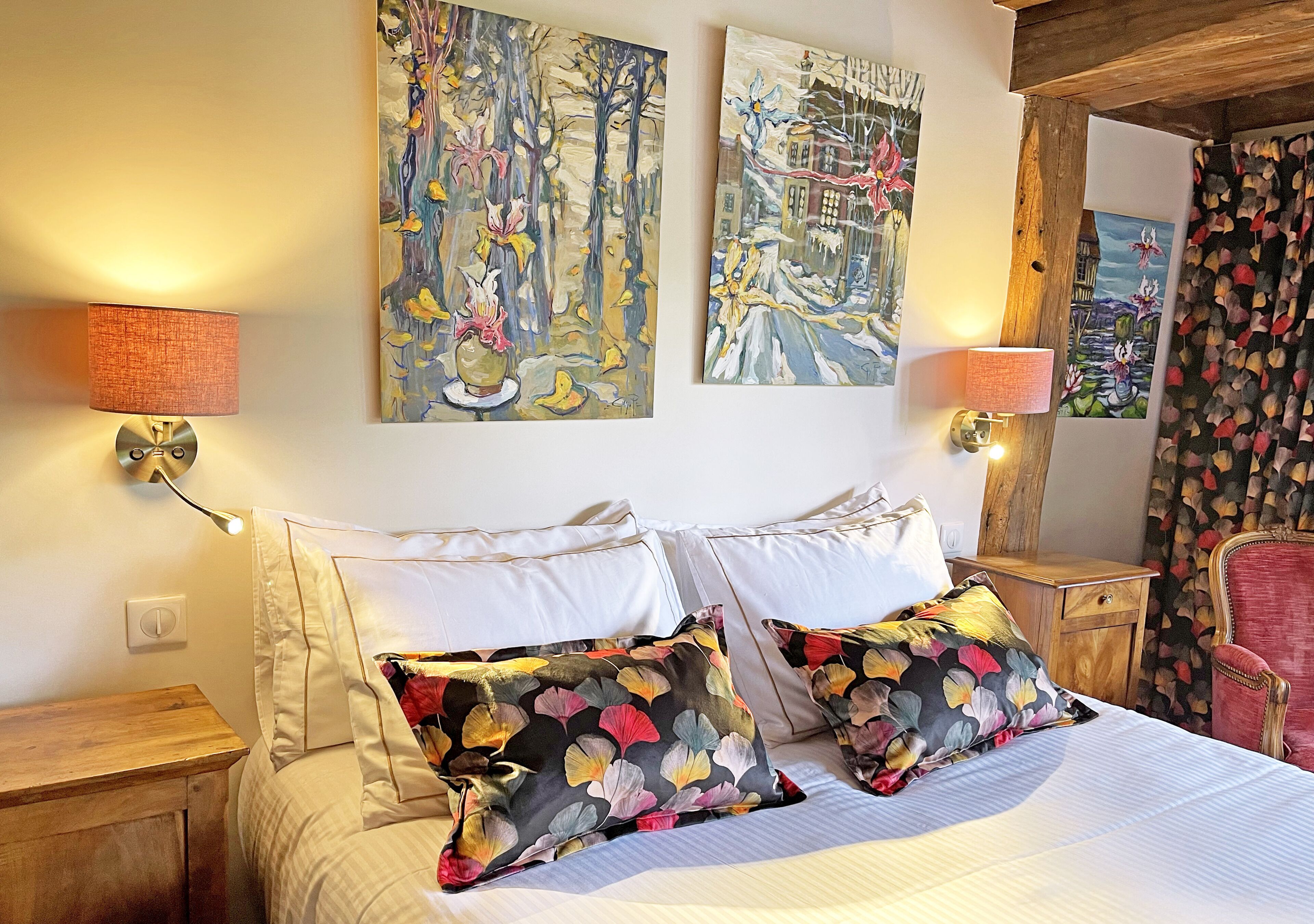 Ein Schlafzimmer mit einem Bett, zwei Wandleuchten und zwei Bildern.