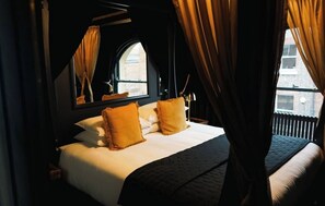 A hotel room with a large bed, a window with curtains, and a view of the outside.