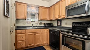 Functional kitchen with microwave, dishwasher, and stove, featuring a sink and ample countertop space.