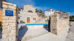 Un bâtiment en pierre doté d’une piscine, d’une porte en bois et d’une enseigne indiquant qu’il s’agit d’un hôtel quatre étoiles.