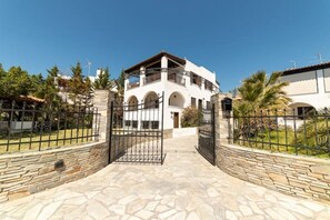 A two-story building with a stone entrance, arched windows, and a balcony.