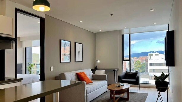 Ein modernes Wohnzimmer mit Sofa, Couchtisch und Essbereich.