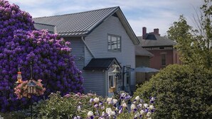 Una casa con jardín delantero, una campana y un farol colgante.
