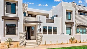 A modern two-story house with a flat roof, large windows, and a stone facade. - Pier 43 At Desert Color: Desert Color Lagoon + Beaches (St. George)