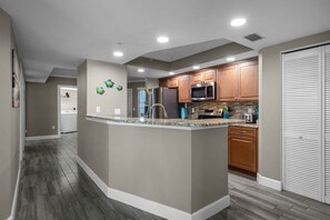 Kitchen features a central island, stainless steel appliances, and wooden cabinetry.