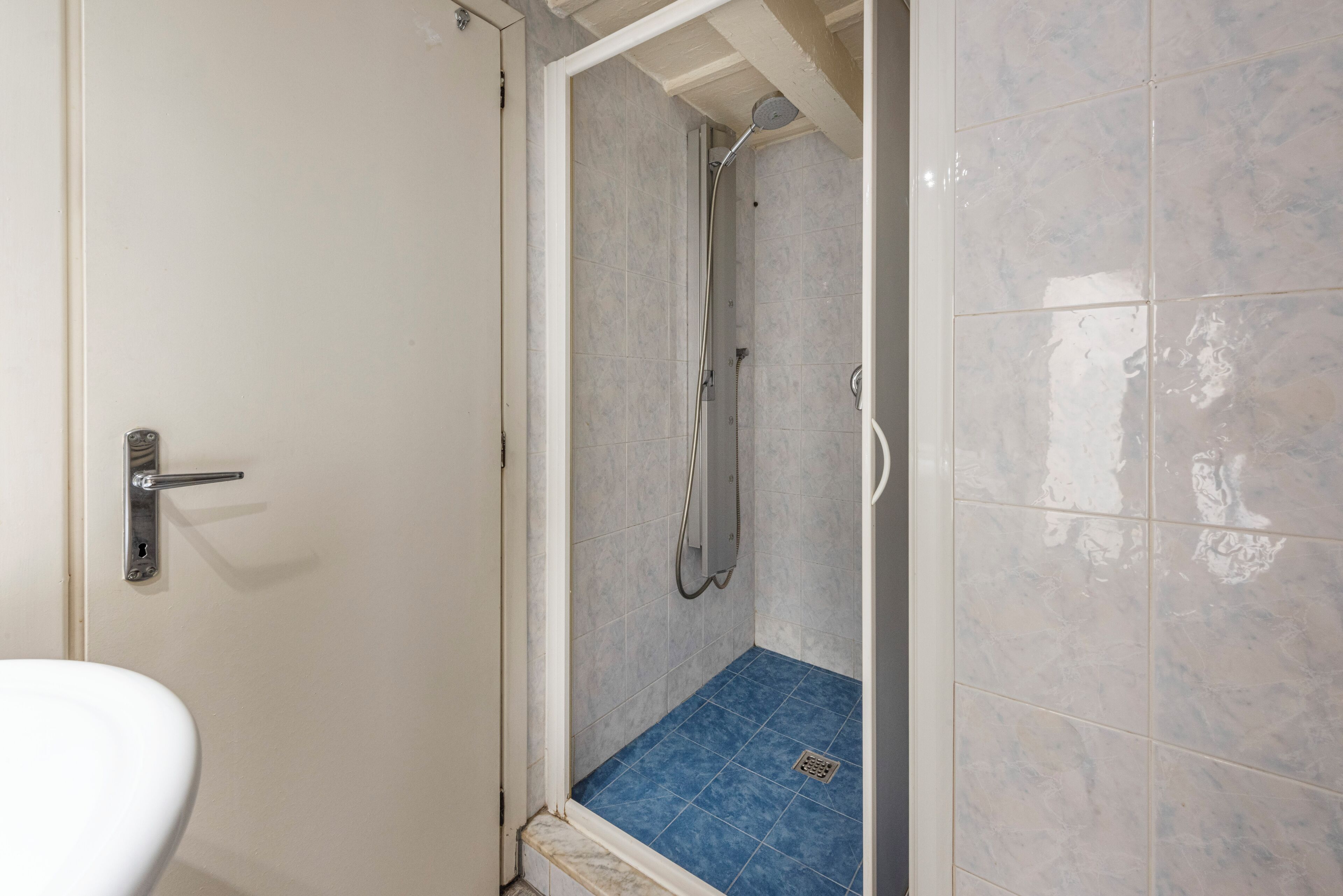 A bathroom with a shower, a toilet, and tiled walls.