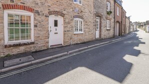 A stone building with a white door labeled "2" and a window with a grid pattern. - Bell Cottage (Dorchester)