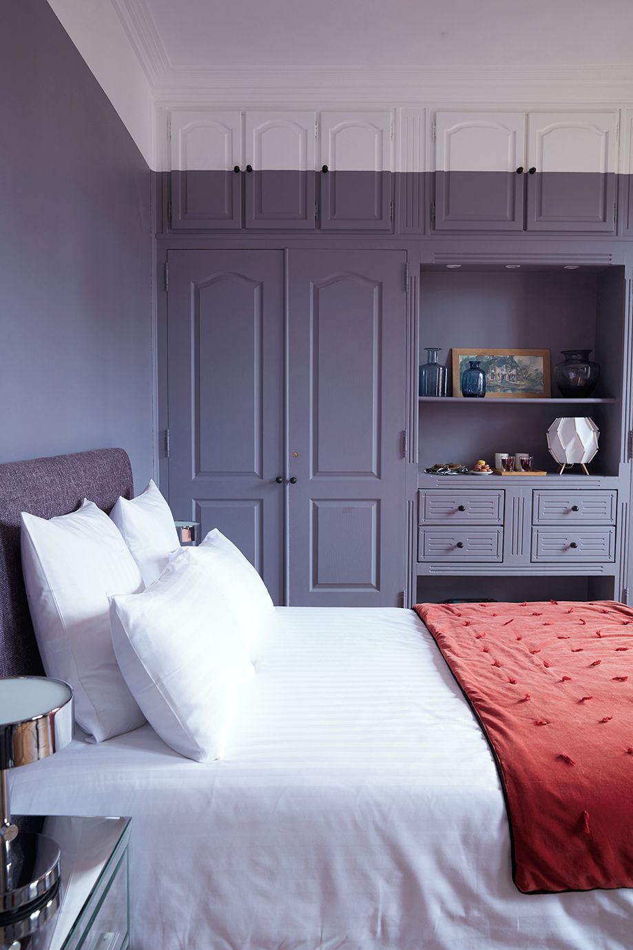 A bedroom with a bed, bedside tables, a dresser, and a wardrobe.