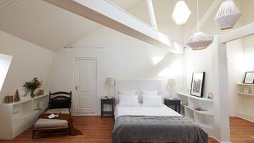 Une chambre à coucher comprenant un lit, des tables de chevet, une commode, un banc et une étagère avec des objets décoratifs.