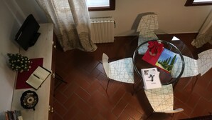 A dining area with a round glass table, two chairs, a small decorative plant, a notebook, and a book titled 'House Rules'. - Sofia's Nest (Firenze)