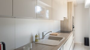 A modern kitchen with a sink, countertop, and cabinets. - Le Palm Beach - Jacuzzi et vue mer (Sanary-sur-Mer)