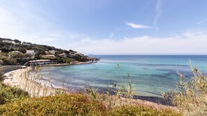 A coastal landscape with a clear view of the sea, a sandy beach, and a hillside with buildings. - Le Palm Beach - Jacuzzi et vue mer (Sanary-sur-Mer)