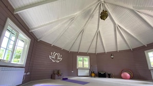 A spacious room with a high ceiling, large windows, and a decorative lotus wall. - Family Home With Large Garden and Pool Near Totnes (Totnes)