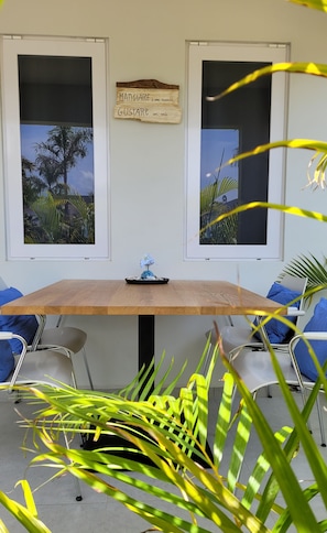 A room with a wooden table, two chairs, a laptop, and a framed picture of a tropical scene. - La Villetta, your home away from home (Willemstad)