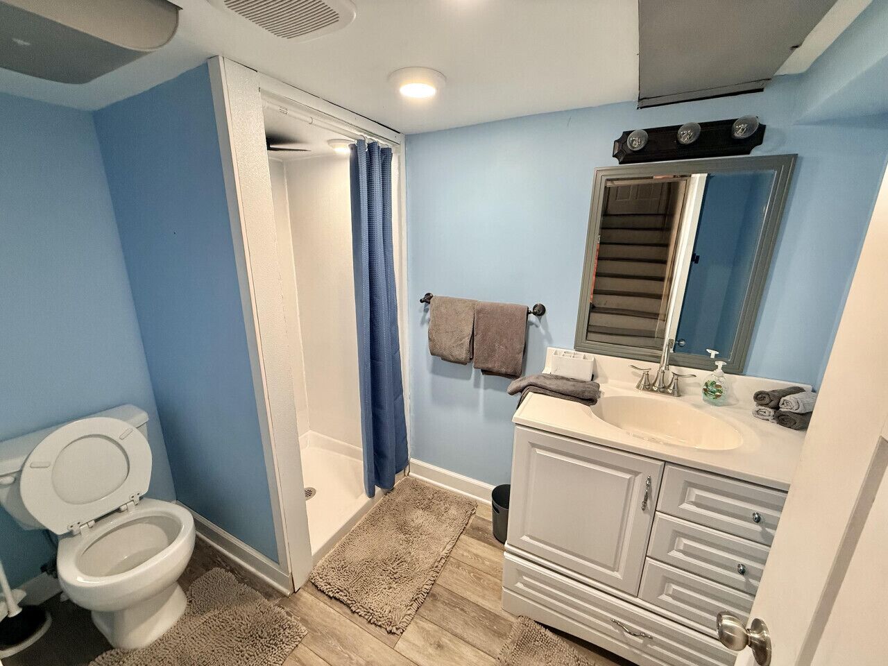 Een badkamer met toilet, wastafel en douche.